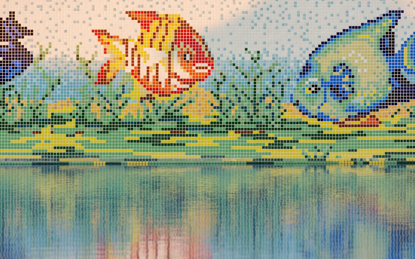 Pixel style mosaic tiles of an orange fish and a green fish above a pool, their reflection blurring in the water